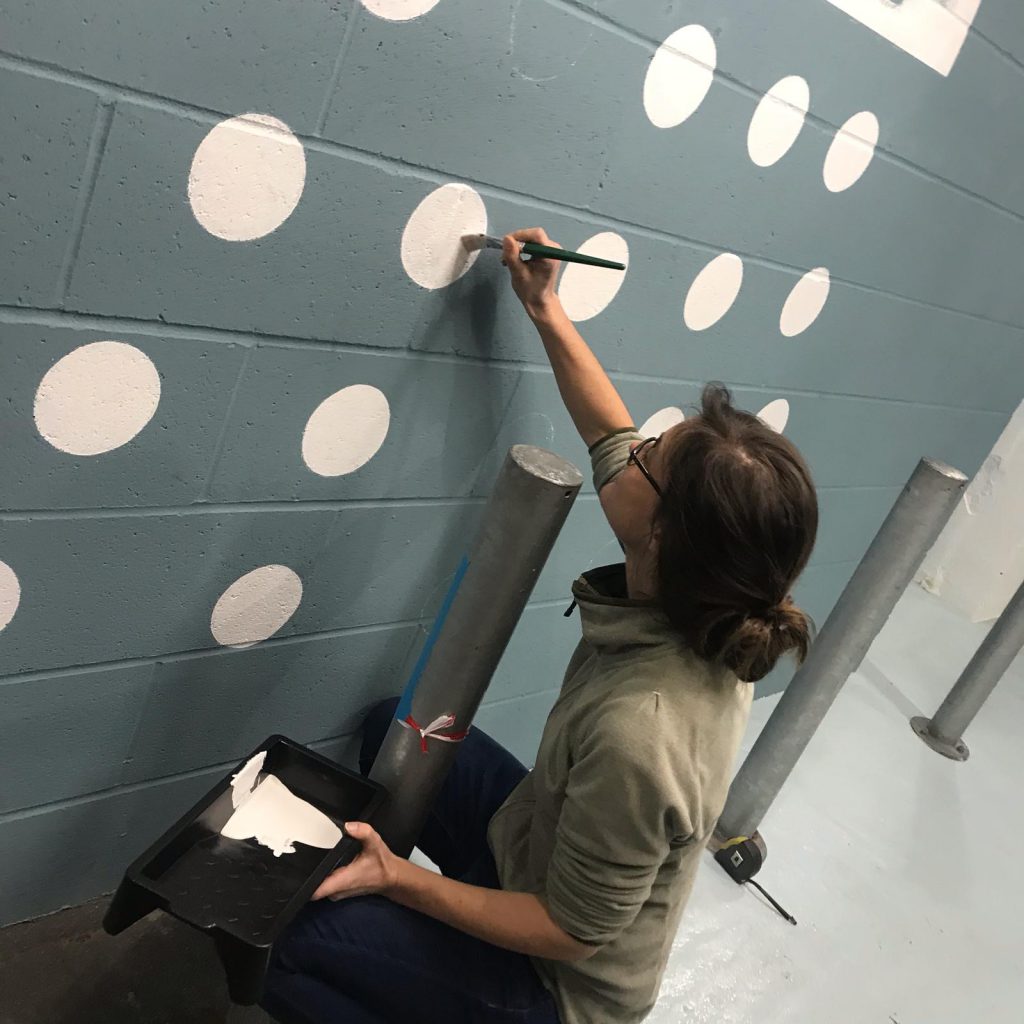 Seraina Signs painting dots on wall murals in London's Covent Garden. Women sign artists Rising star Sign Painter. Painted House numbers names Lead times + prices.