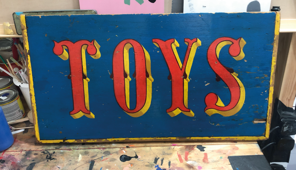 Hand Painted Toy Box Restoration, Gilded Xmas sign panel for Sothebys London.

Gold Transom signs, Sign Writing Motcomb Walton Street, art gallery roman lettering signage by Seraina Signs London.