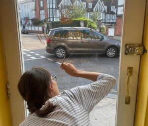 Seraina gilding lettering on glass at De Gournay Fulham London