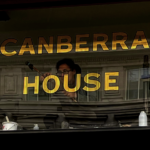 Seraina Gilding lettering on glass at Canberra House Central London sign gilder. Gold leaf lettering. Soho Bold for Canberra house LDN