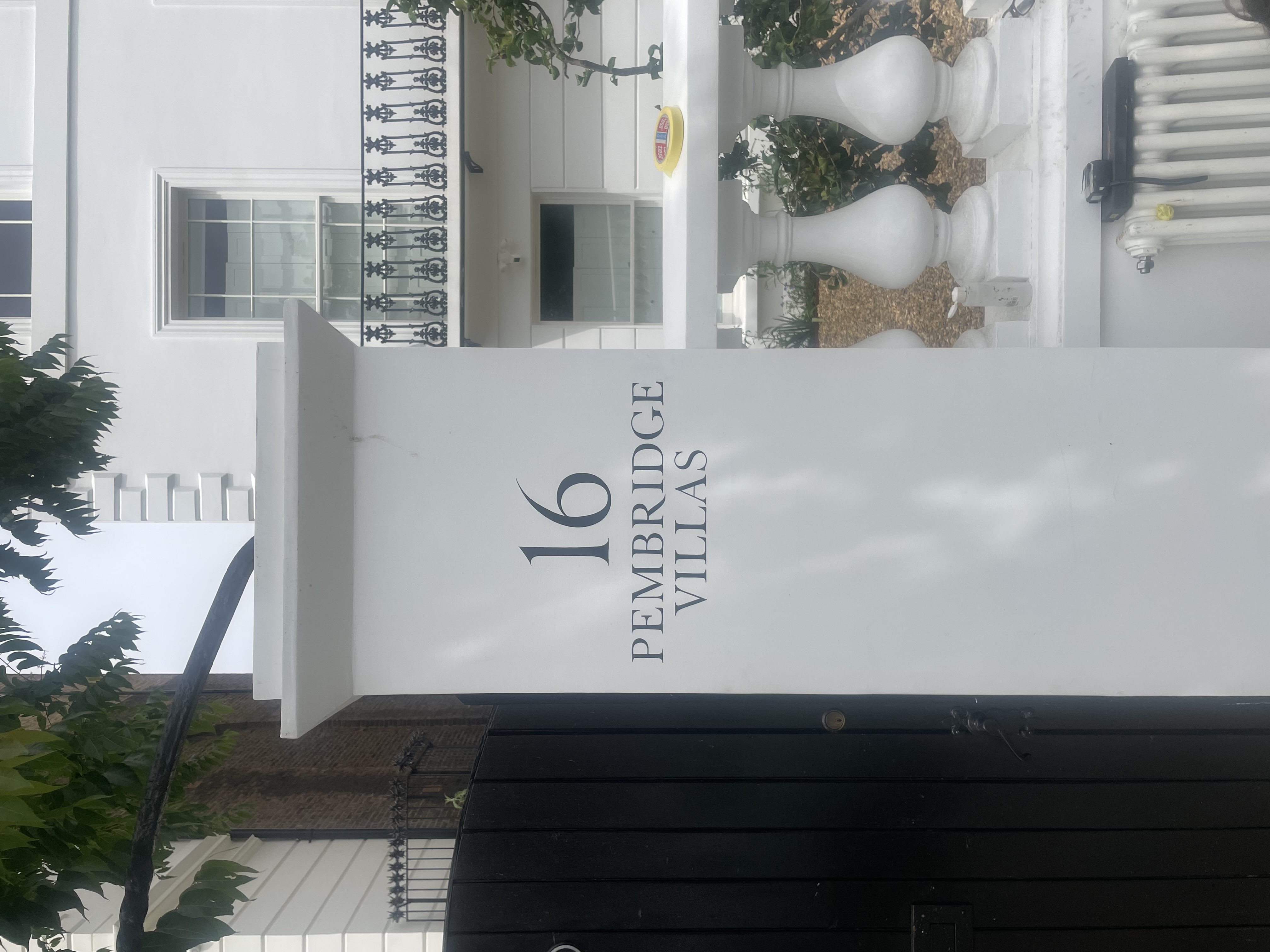 White pillar with hand painted number 16 and 'PEMBRIDGE VILLAS' NGS Signs