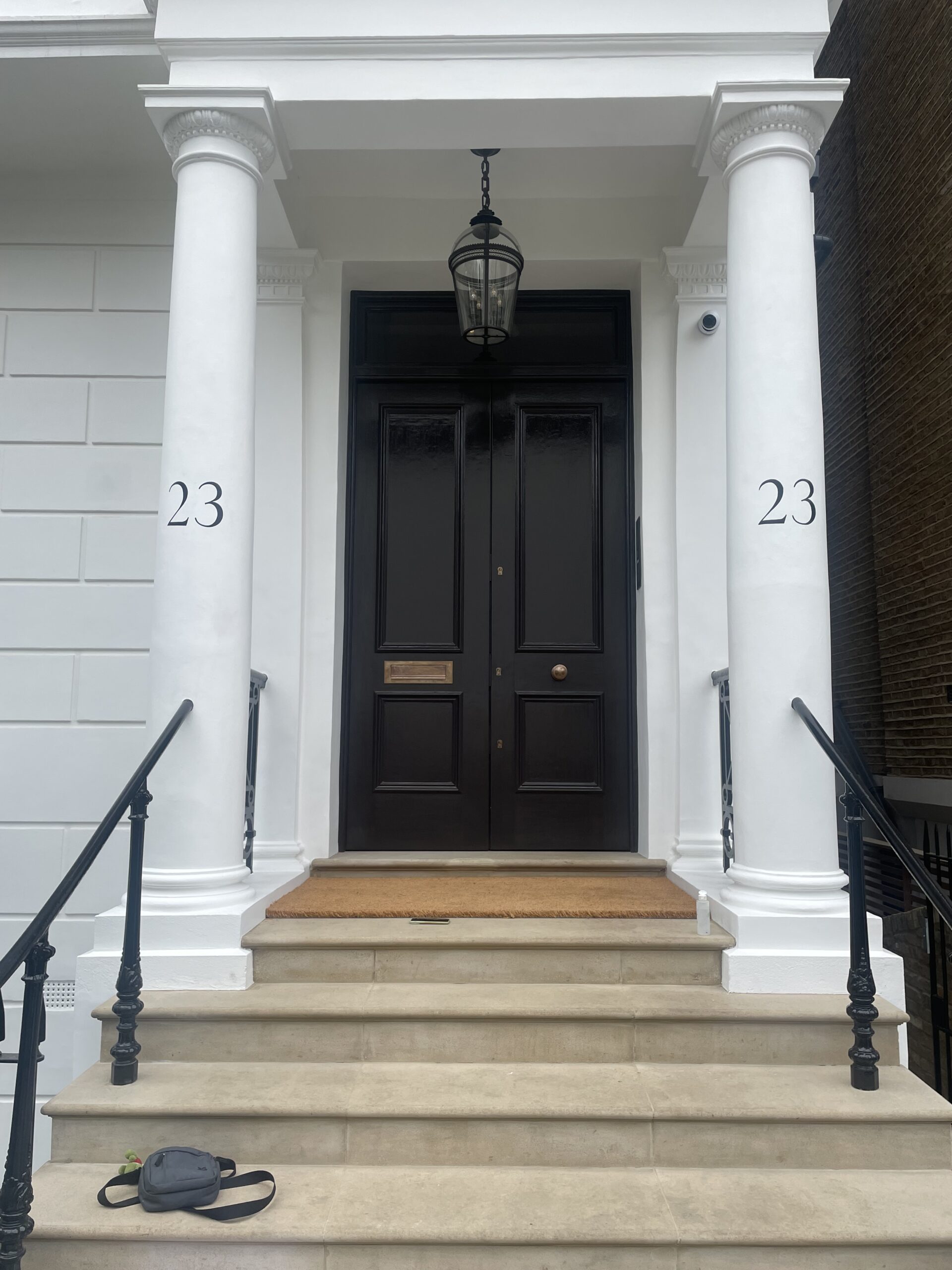 White-columned Numbers sign written house entrance with black lettering