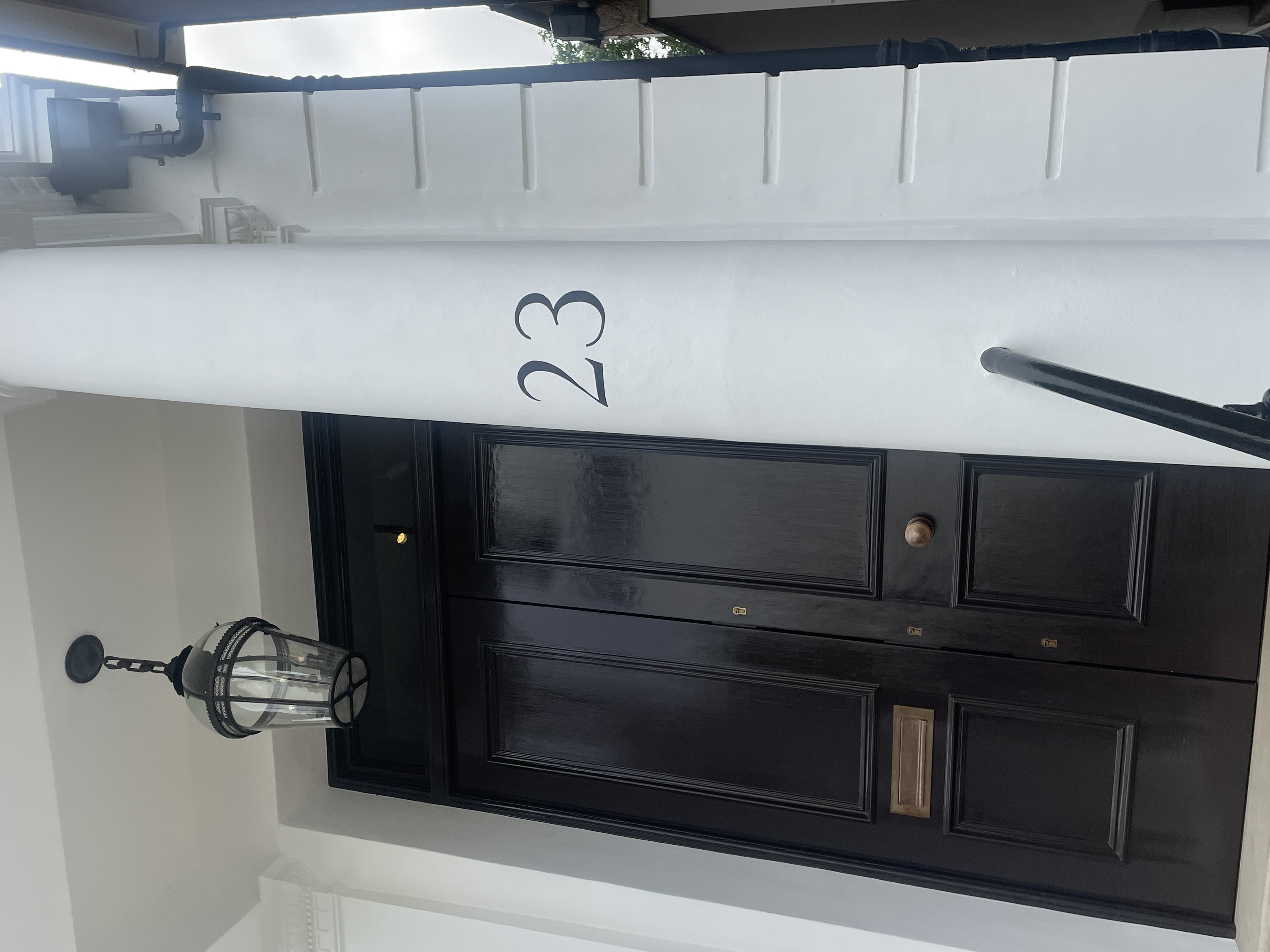 White pillar with hand painted number 16 and 'PEMBRIDGE VILLAS' NGS Signs